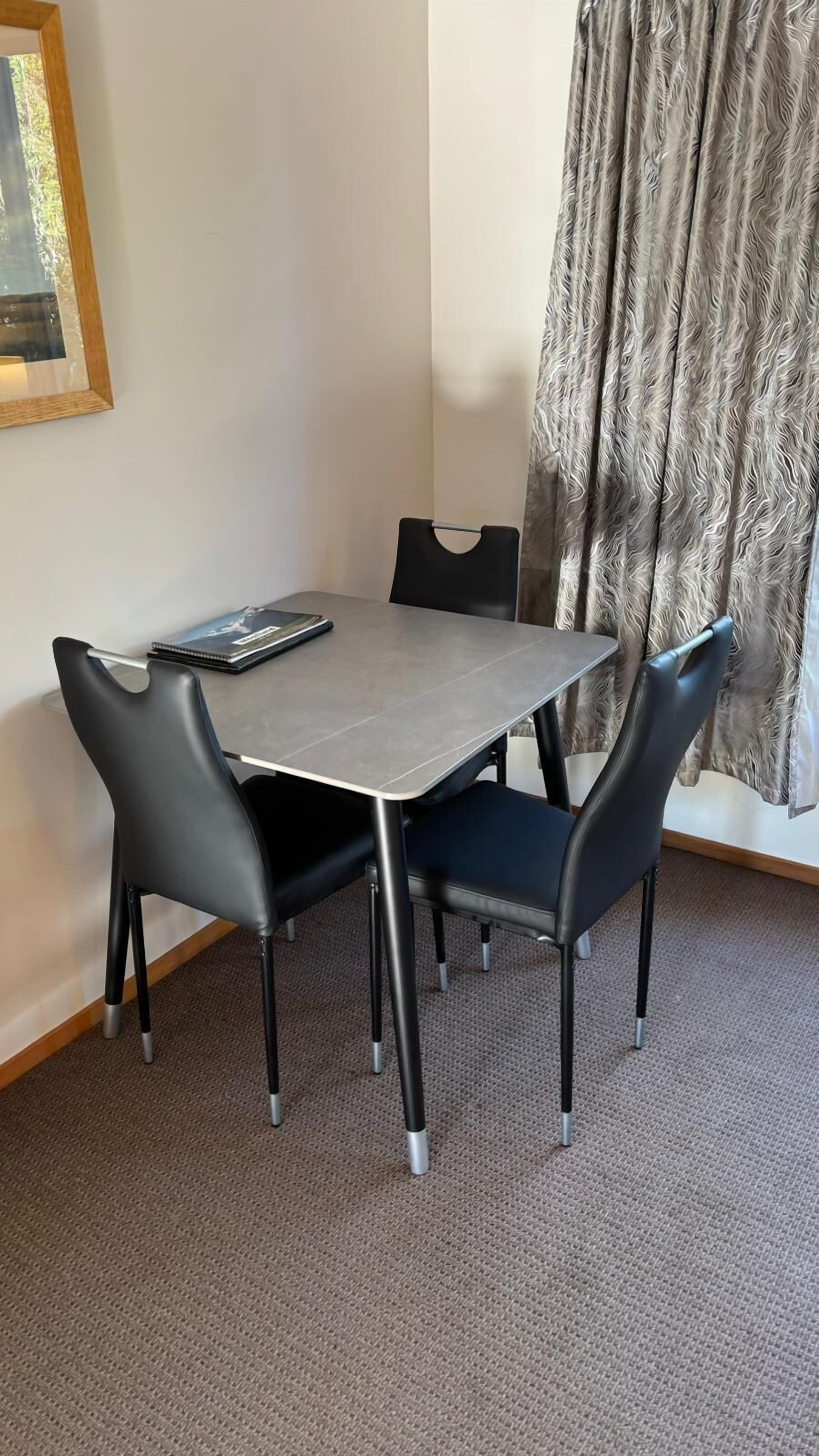 Un petit coin repas avec une table et quatre chaises.