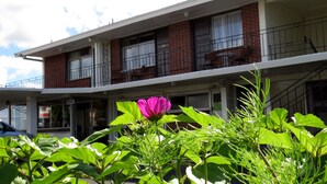 Un immeuble à plusieurs étages, doté d’une façade en briques, de nombreuses fenêtres et d’un balcon.