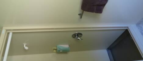 A bathroom with a bathtub, a towel rack, and a soap dispenser.