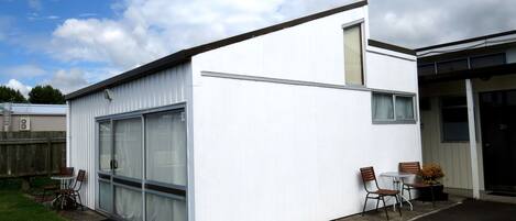 A modern white building with large windows and a small attached structure.