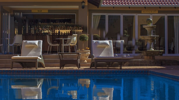 A poolside area with lounge chairs and a bar.