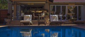 Un espace aménagé au bord de la piscine, avec des chaises longues et un bar.