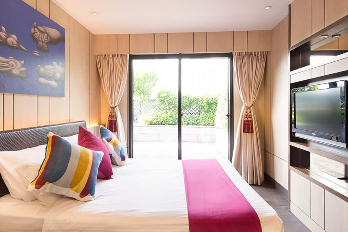 Een hotelkamer met een bed, een televisie en uitzicht op de omgeving.