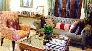 A living room with a sofa, armchair, and coffee table. There are books and a plant on the coffee table. - La Pillow8 (Chiang Mai)