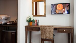 A room with a wooden desk, a chair, a mirror, a television, and a small potted plant. - La Pillow8 (Chiang Mai)