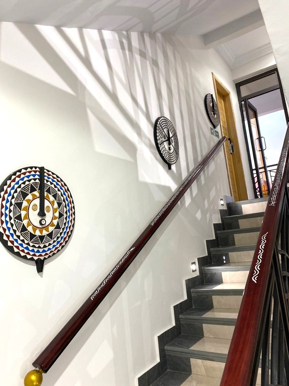 A staircase with a wooden handrail and decorative wall art.