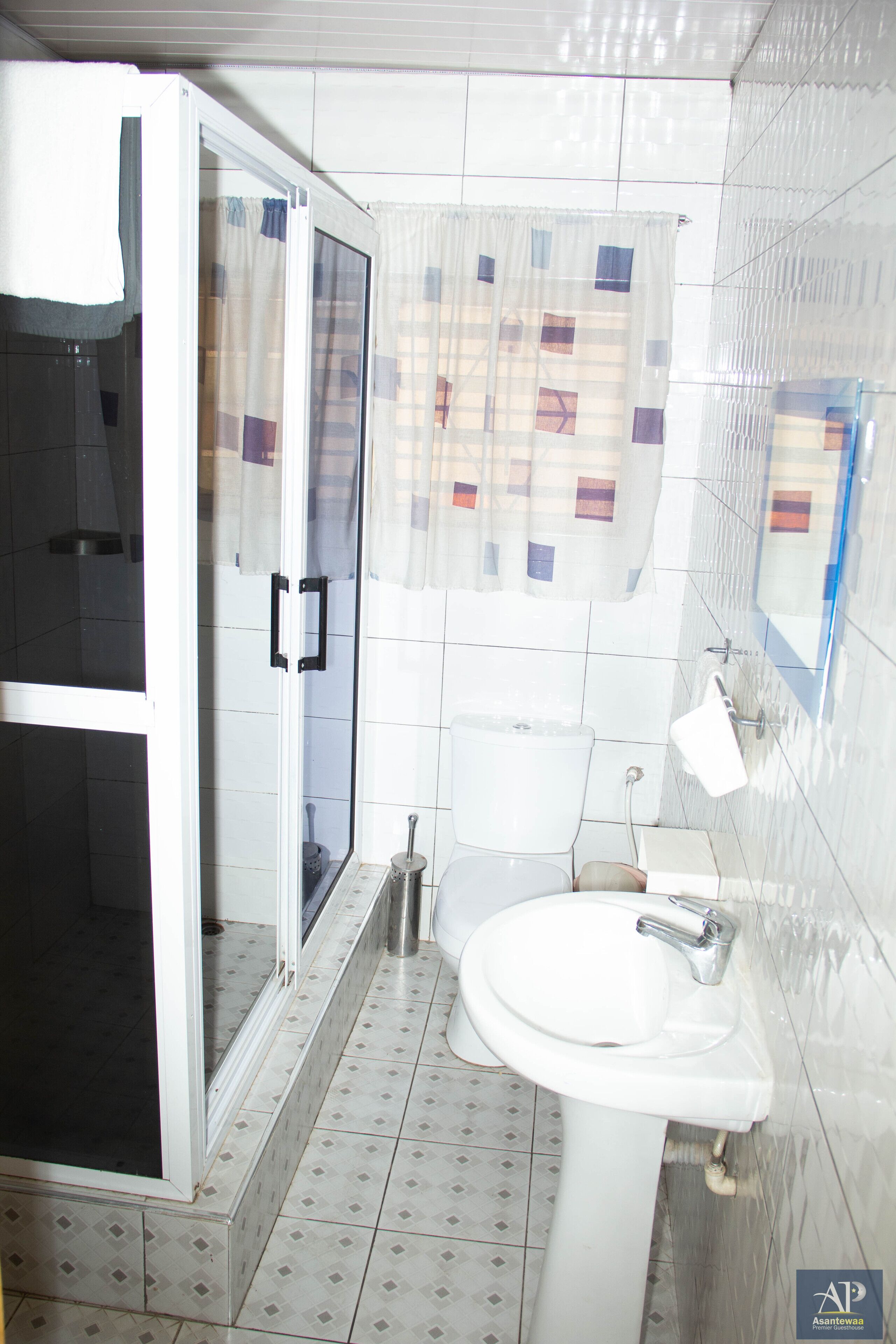 A bathroom with a shower, toilet, and sink.