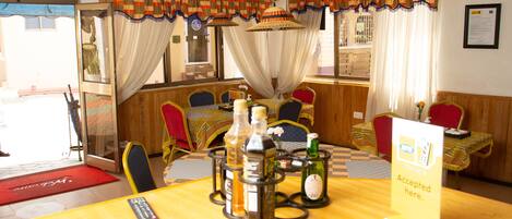 A restaurant with a wooden interior, a central table with bottles, and a sign indicating acceptance of credit cards.