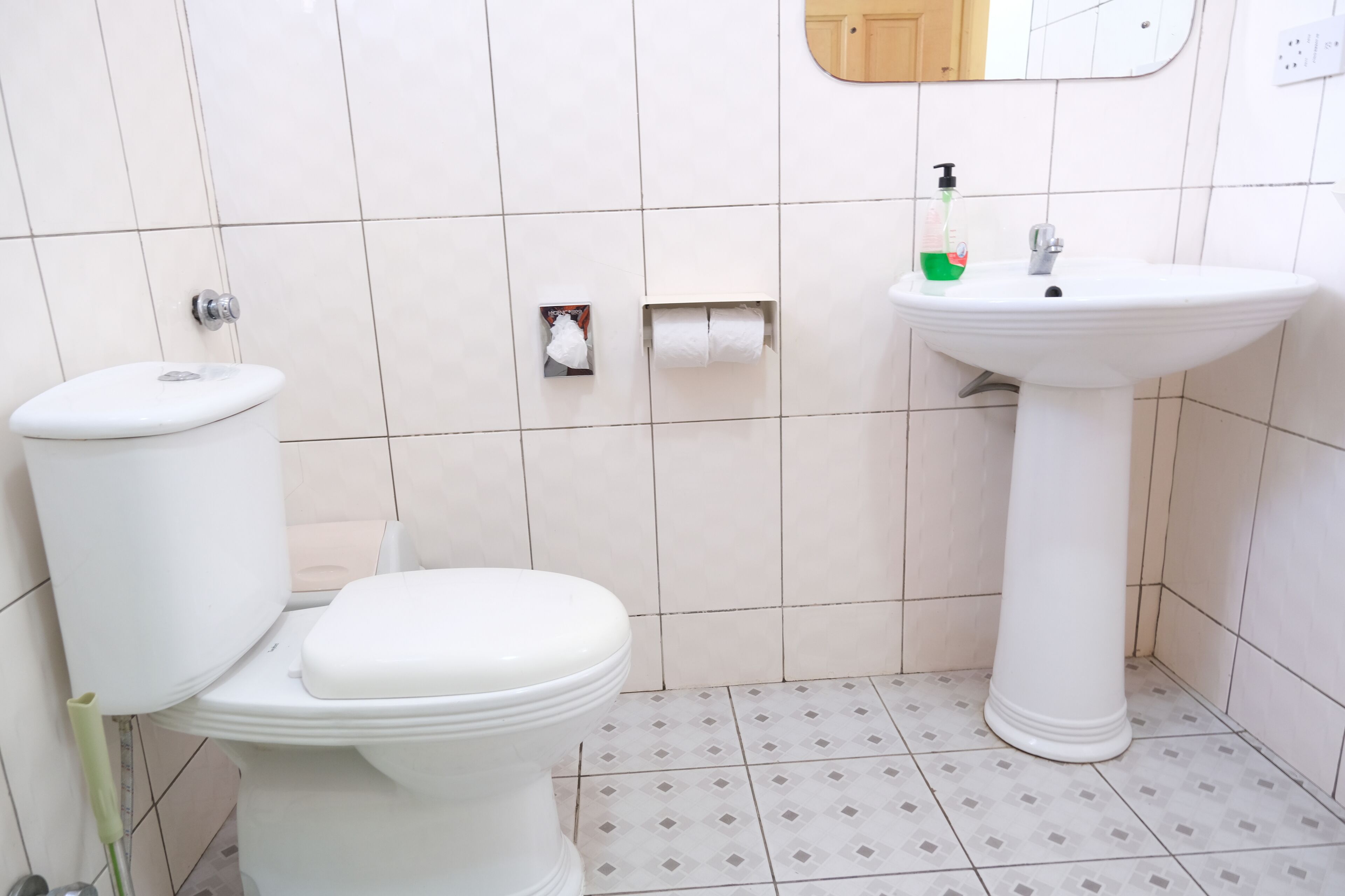 Un bagno con il water, un lavandino e uno specchio.