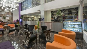 A modern lobby with seating areas, a reception desk, and a display case with items. - Hive Hotel and Convention Place (Quezon City)