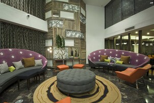 A spacious lobby with two sofas, a round ottoman, and a coffee table.