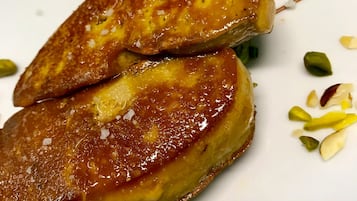 Un plato con dos tortitas doradas, espárragos verdes y hierbas verdes picadas.