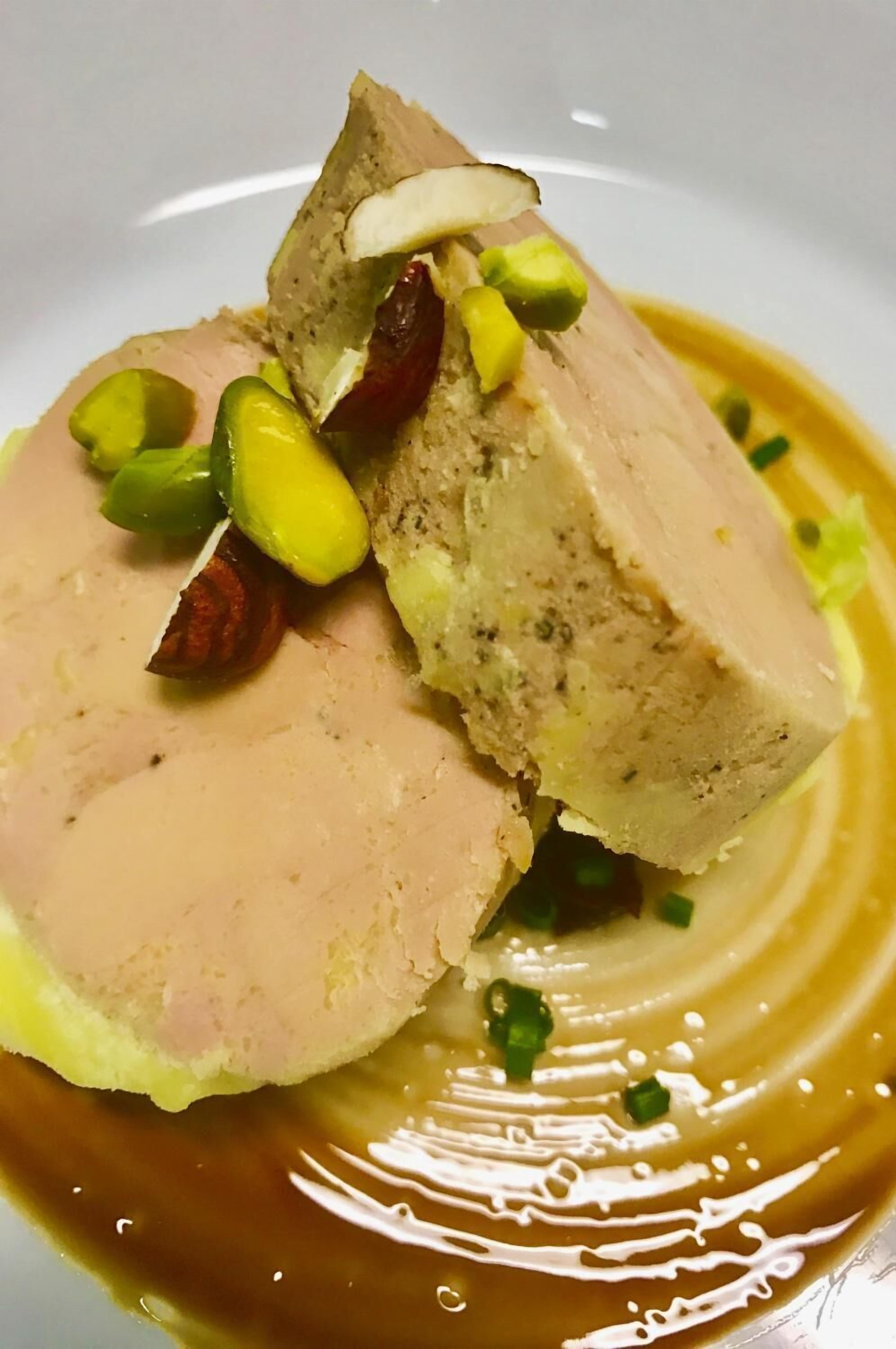 Un plat composé d’une tranche de viande, de pistaches et d’une sauce.