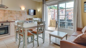Una cocina moderna con comedor, sofá y vistas al exterior.