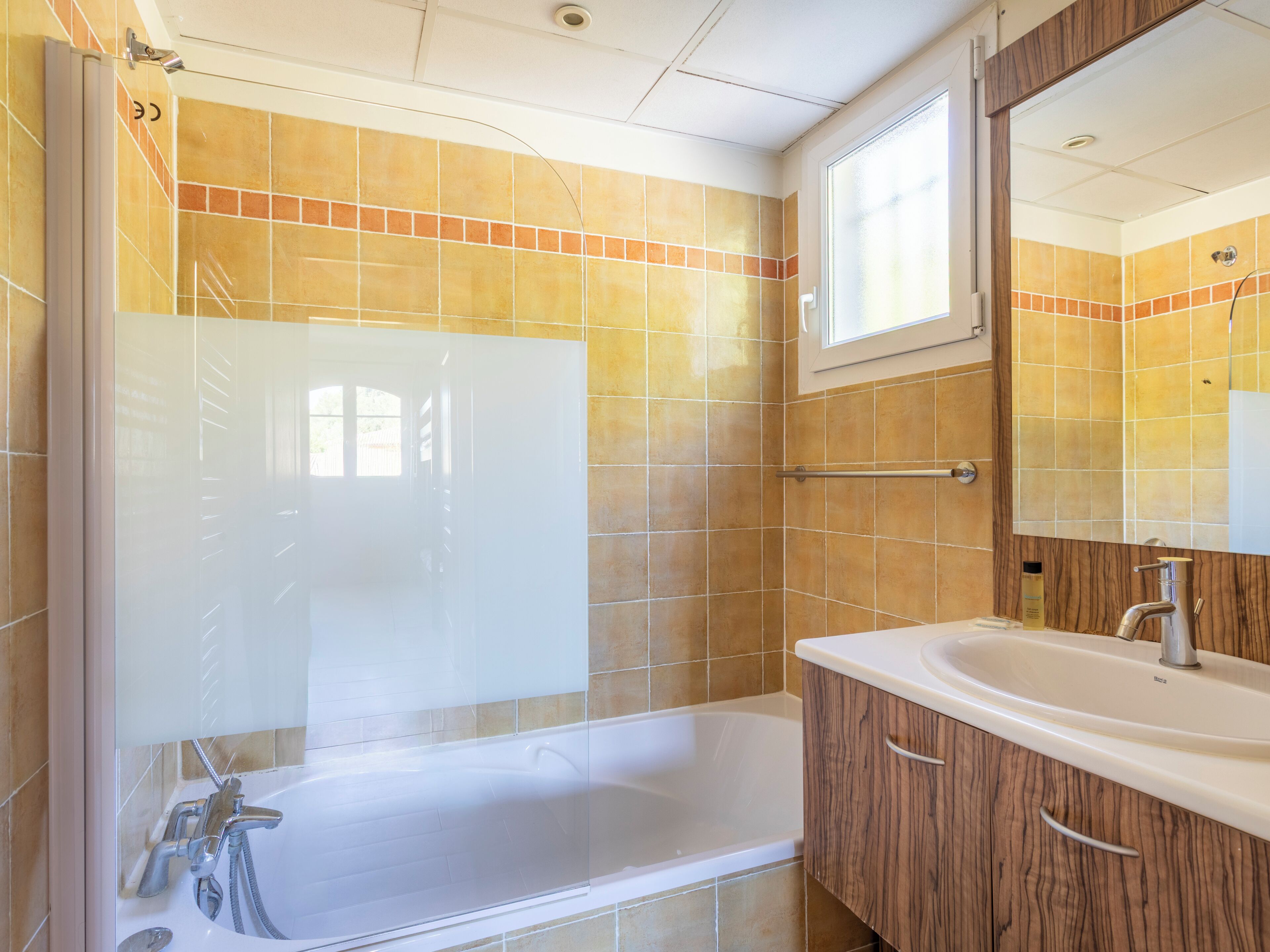 A bathroom with a bathtub, a sink, and a mirror.