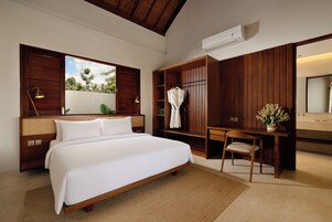 Un dormitorio con una cama grande, un armario de madera y un escritorio con silla.