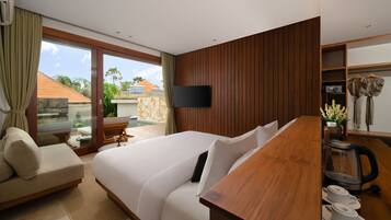 Ein modernes Hotelzimmer mit einem großen Bett, einem Holztisch, einem Flachbildfernseher und Blick ins Freie.