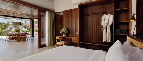 A modern hotel room with a large bed, wooden wardrobe, and a desk with a chair.