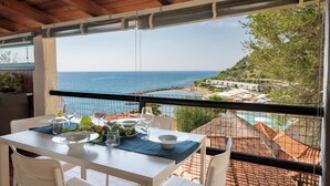 Un espace repas avec vue sur la mer et une piscine.