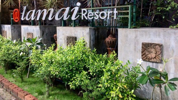 A sign for Tamai Resort with a lush green garden in the foreground. - At Lamai Resort (Koh Samui)