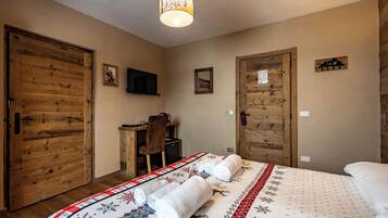 Una habitación con una cama, puertas de madera, un escritorio y una silla.