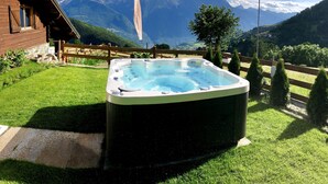 Un jacuzzi en un jardín con vistas a la montaña.