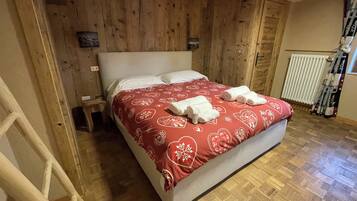 Una habitación con paneles de madera, una cama, una escalera y un radiador.