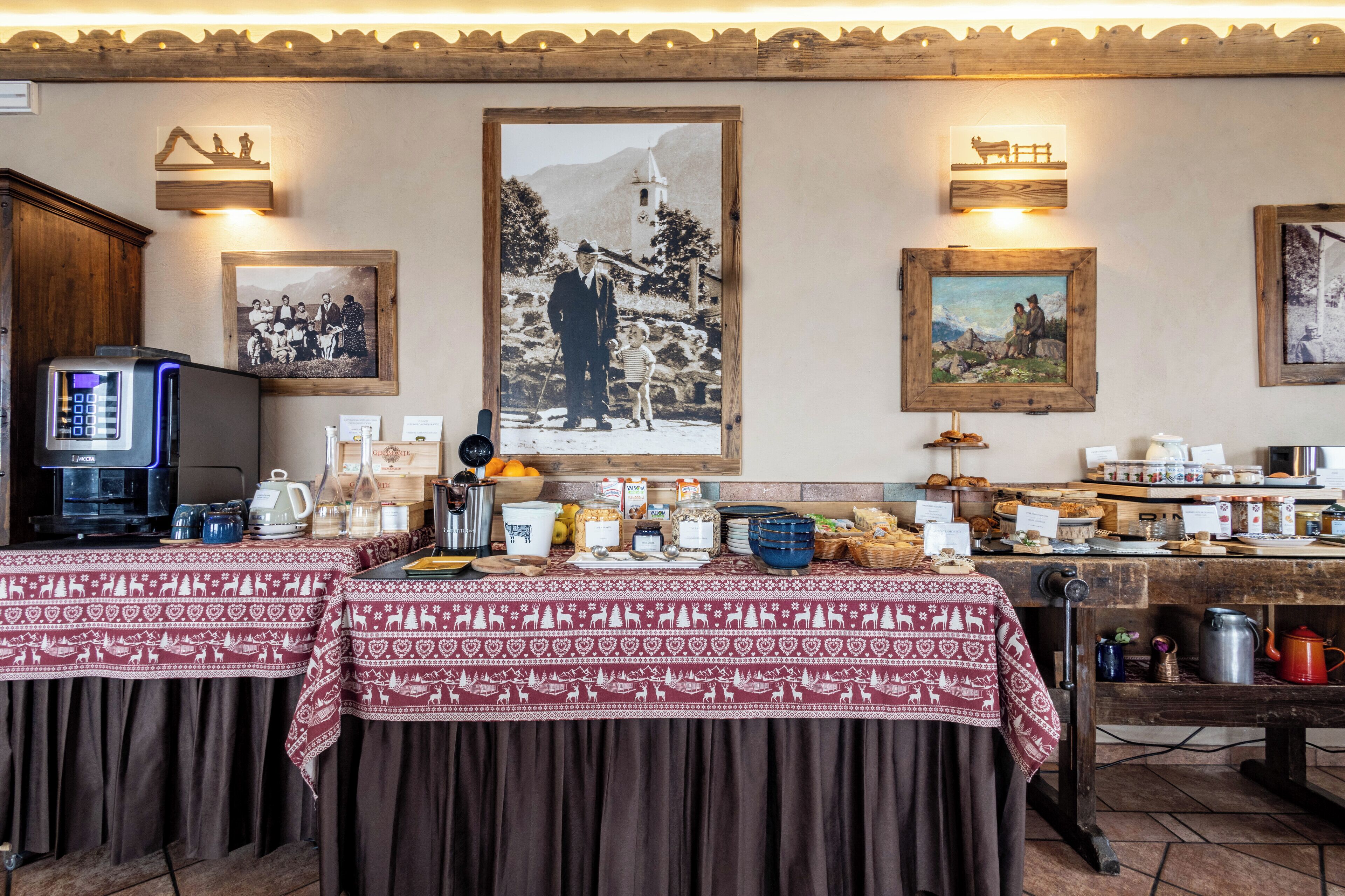 Un espace repas avec un buffet, comprenant une machine à café, divers plats et une grande image encadrée accrochée au mur.
