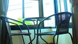A corner room with two chairs, a window, and curtains. - Chiang Mai P Place - Adults Only (Chiang Mai)