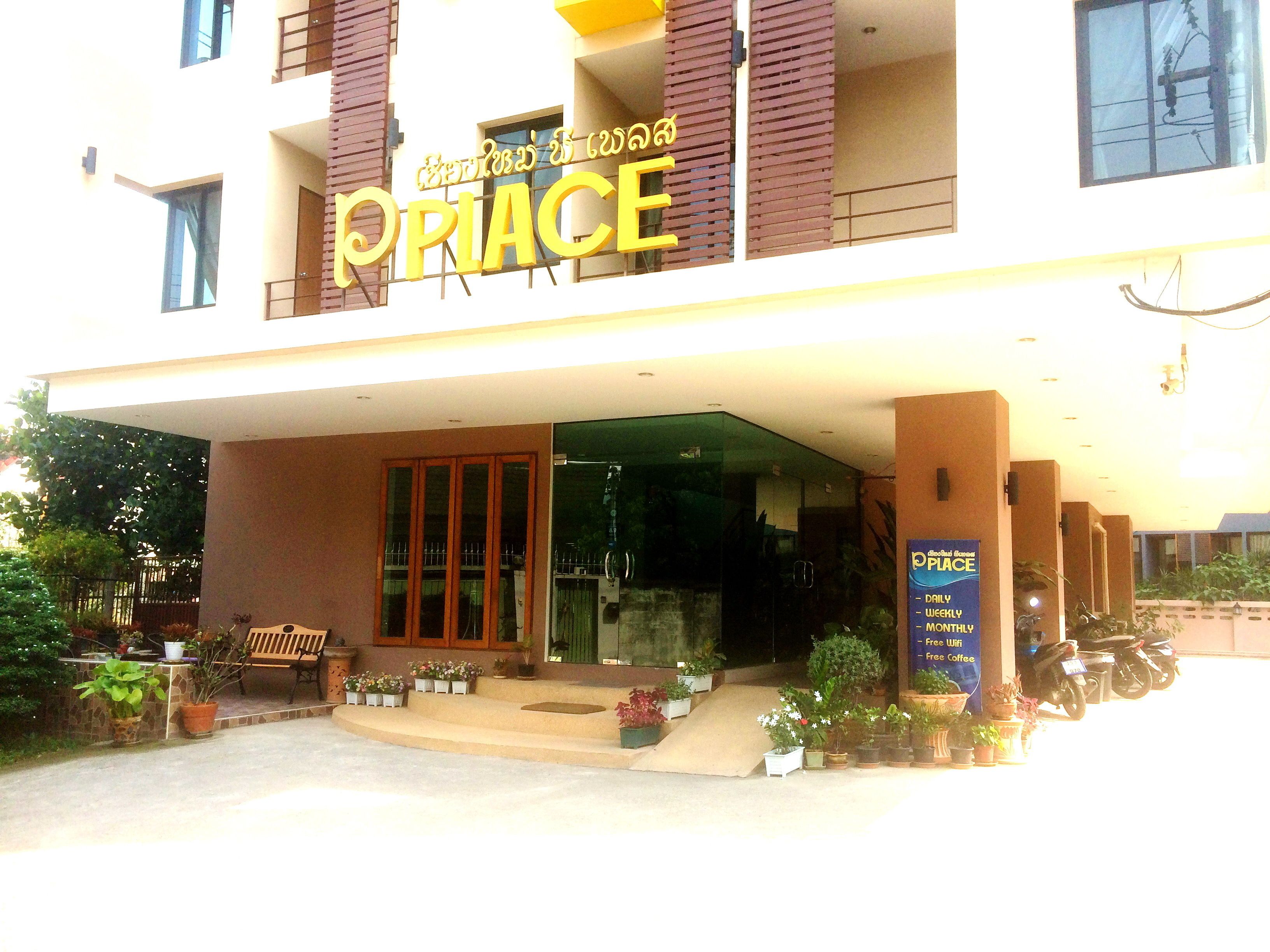 A building with a sign reading "PRiACE" and a signboard advertising daily, weekly, and monthly rates.