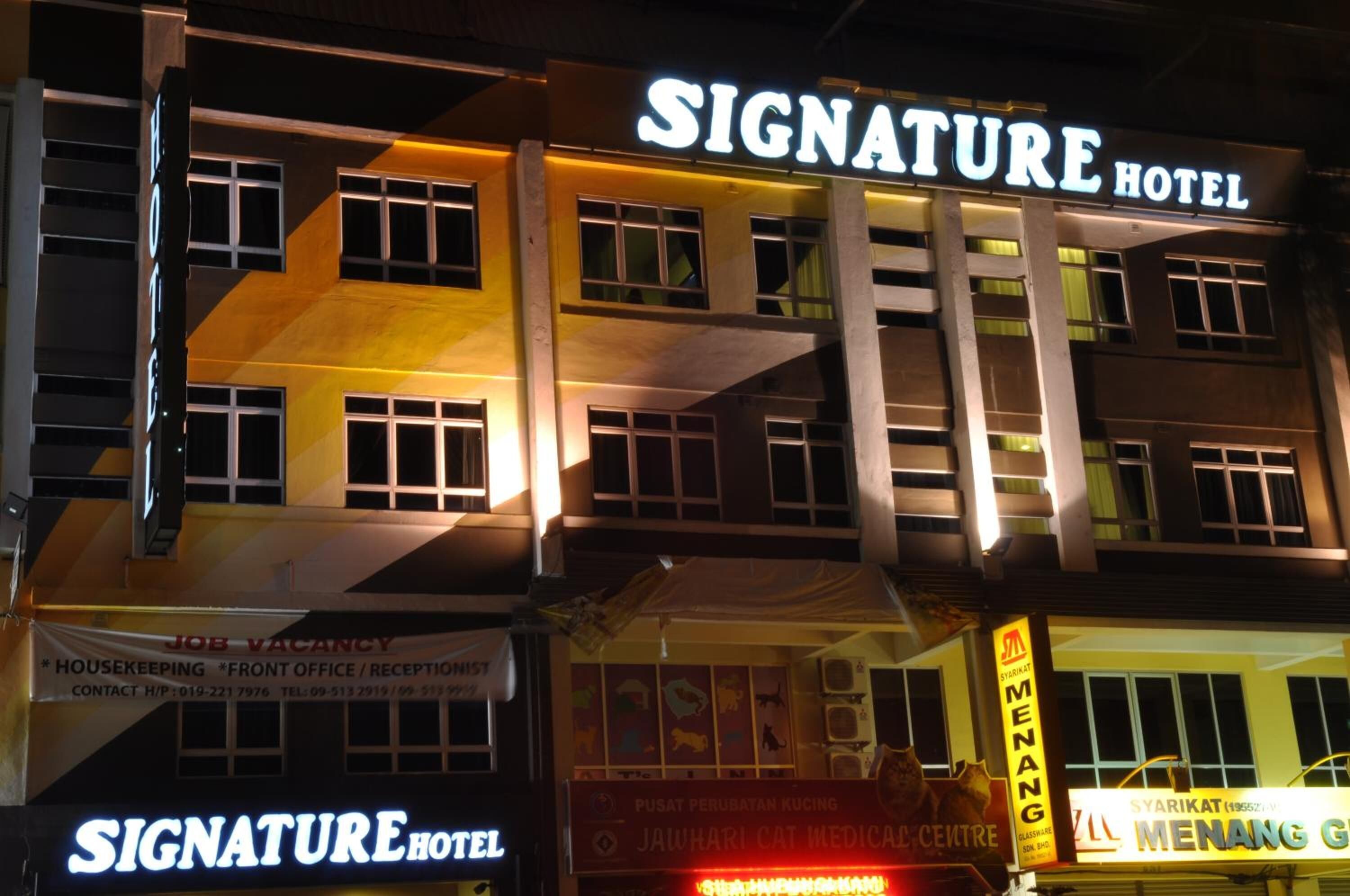 A multi-story building with a prominent 'Signature Hotel' sign.