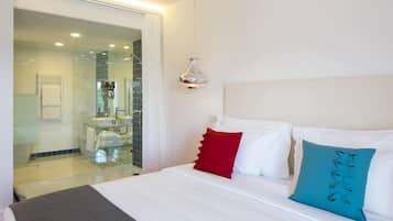 Une chambre d’hôtel avec un lit, une douche en verre et un luminaire suspendu.