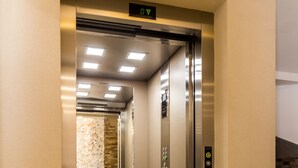 An elevator with a digital display, a handrail, and a tiled floor. - Adriatik Budva apartments (Budva)