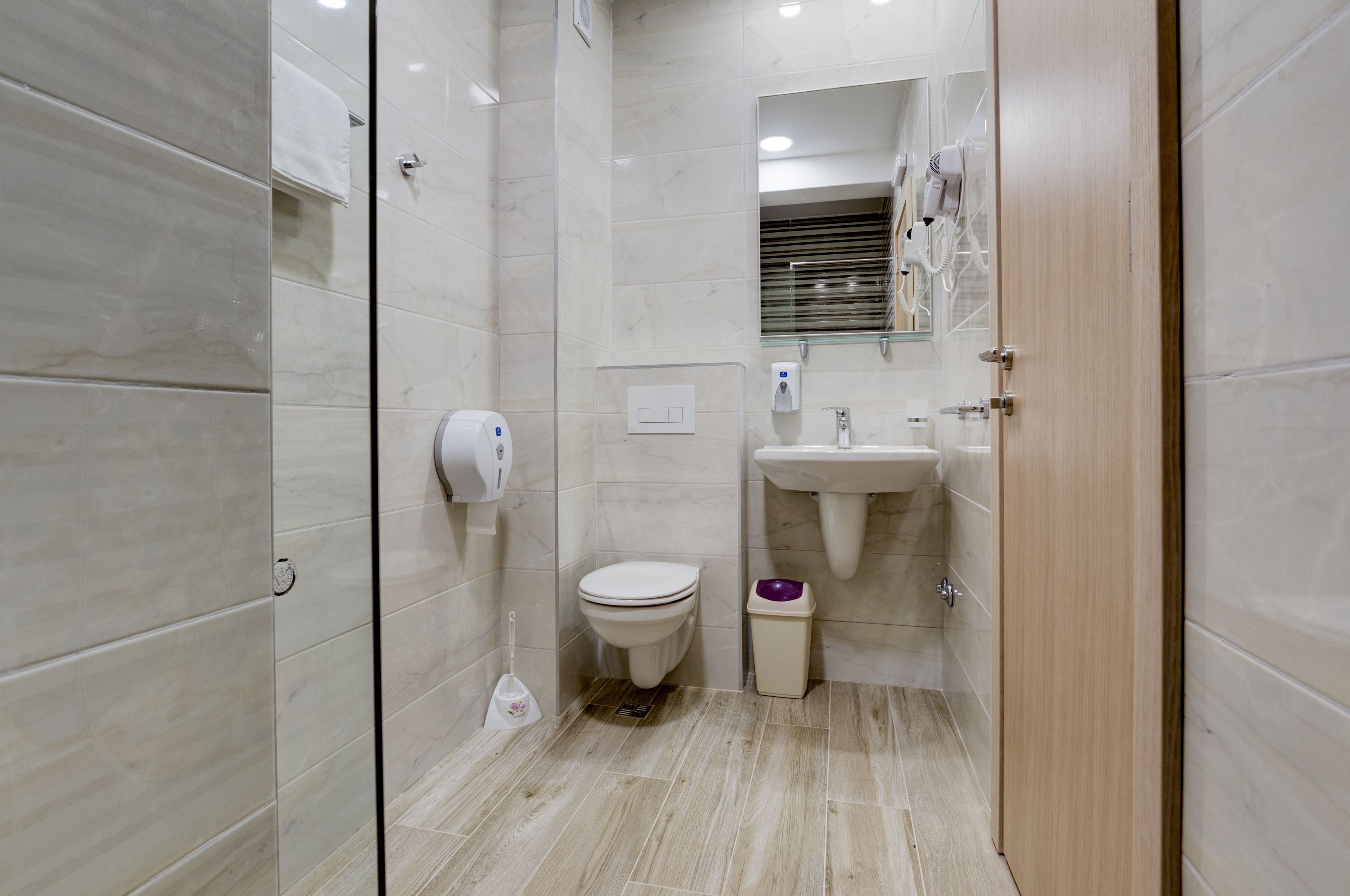 Une salle de bain moderne équipée de toilettes, d’un lavabo et d’un sèche-mains.