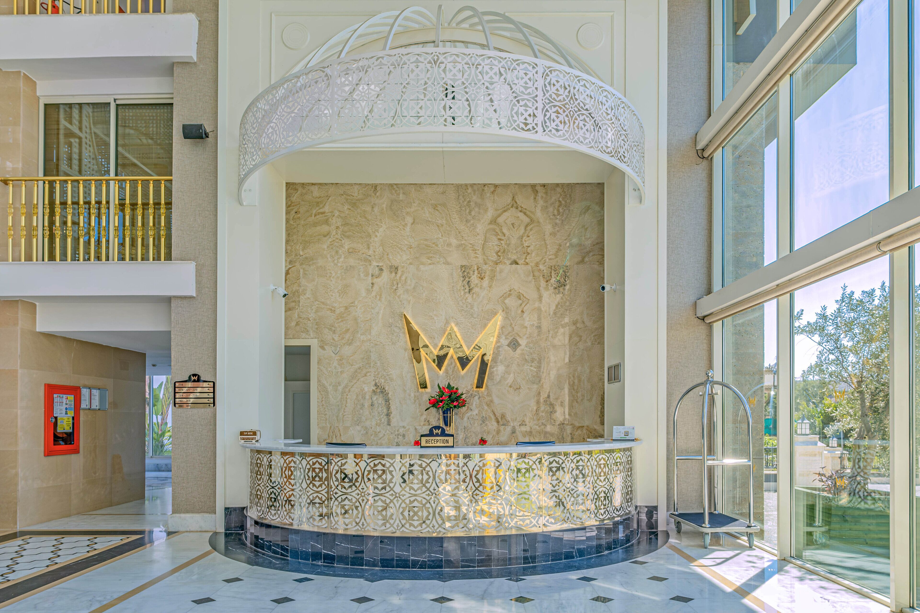 A reception area with a decorative wall, a reception desk, and a glass door leading outside.