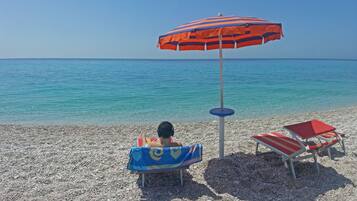 Aan een privéstrand, parasols, een strandbar