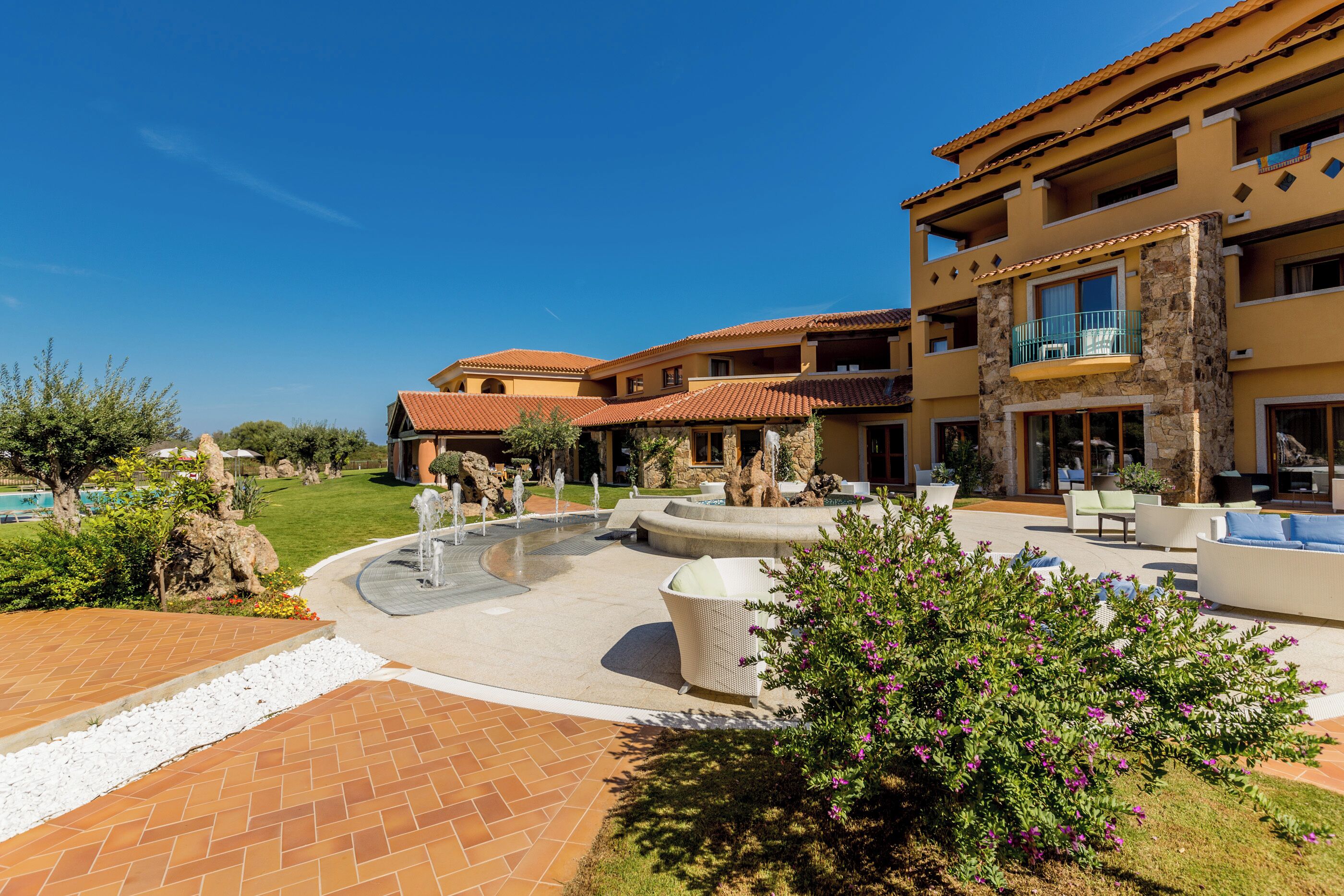 Ein Resort mit Poolbereich, Sitzgelegenheiten im Freien und einem angelegten Garten.