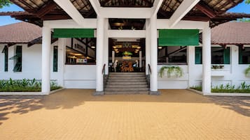 A building with a covered entrance, steps leading up to it, and a tiled floor.