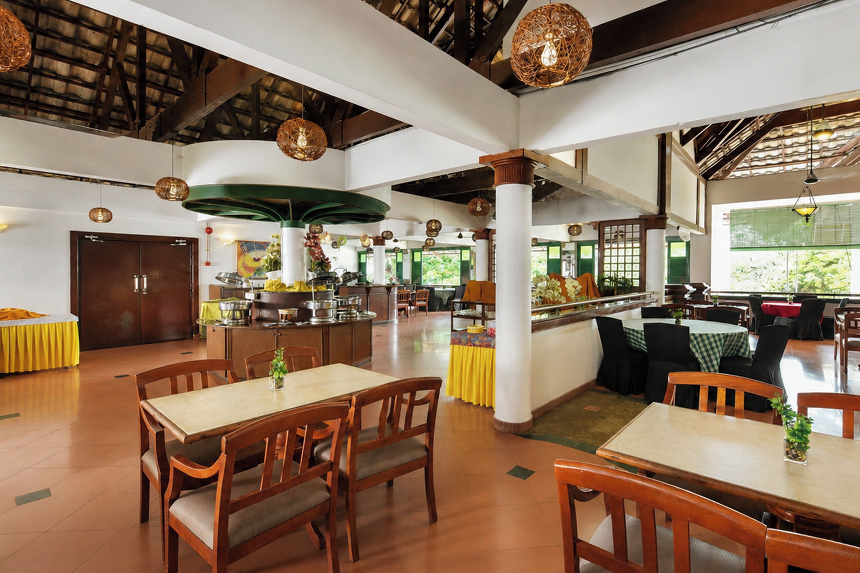 Ein geräumiges Restaurant mit hohen Decken, Holzbalken und verschiedenen Sitzmöglichkeiten, darunter Tische und Stühle.