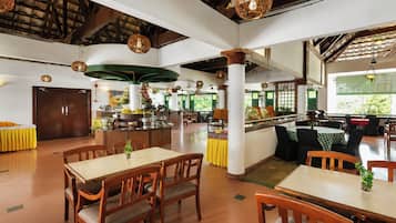 Ein geräumiges Restaurant mit hohen Decken, Holzbalken und verschiedenen Sitzmöglichkeiten, darunter Tische und Stühle.