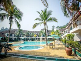 Una piscina al aire libre, sombrillas, tumbonas