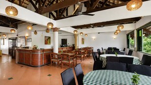 A restaurant with a high ceiling, wooden beams, and a mix of round and rectangular tables. - Sunday Kuantan Near Cherating Beach Formerly Residence Inn (Cherating)