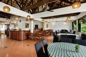 A restaurant with a high ceiling, wooden beams, and a mix of round and rectangular tables. - Sunday Kuantan Near Cherating Beach Formerly Residence Inn (Cherating)