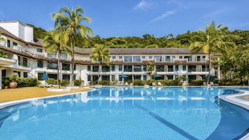 Una piscina al aire libre, sombrillas, sillones reclinables de piscina