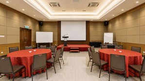 A conference room with a stage, a whiteboard, and multiple tables with chairs. - Sunday Kuantan Near Cherating Beach Formerly Residence Inn (Cherating)