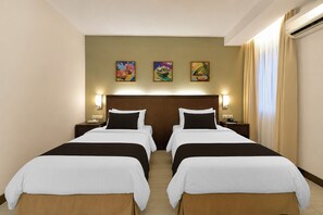 A hotel room with two beds, a wooden headboard, bedside lamps, and three wall-mounted paintings. - Sunday Kuantan Near Cherating Beach Formerly Residence Inn (Cherating)