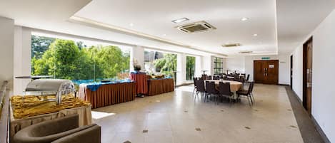 Un vaste espace intérieur aménagé avec un buffet, de grandes fenêtres et un long couloir.