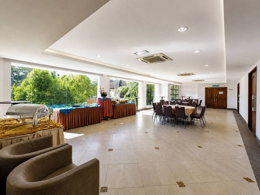 A spacious indoor area with a buffet setup, large windows, and a long corridor.
