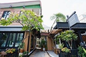 Un estrecho callejón con plantas en macetas y un banco de madera.