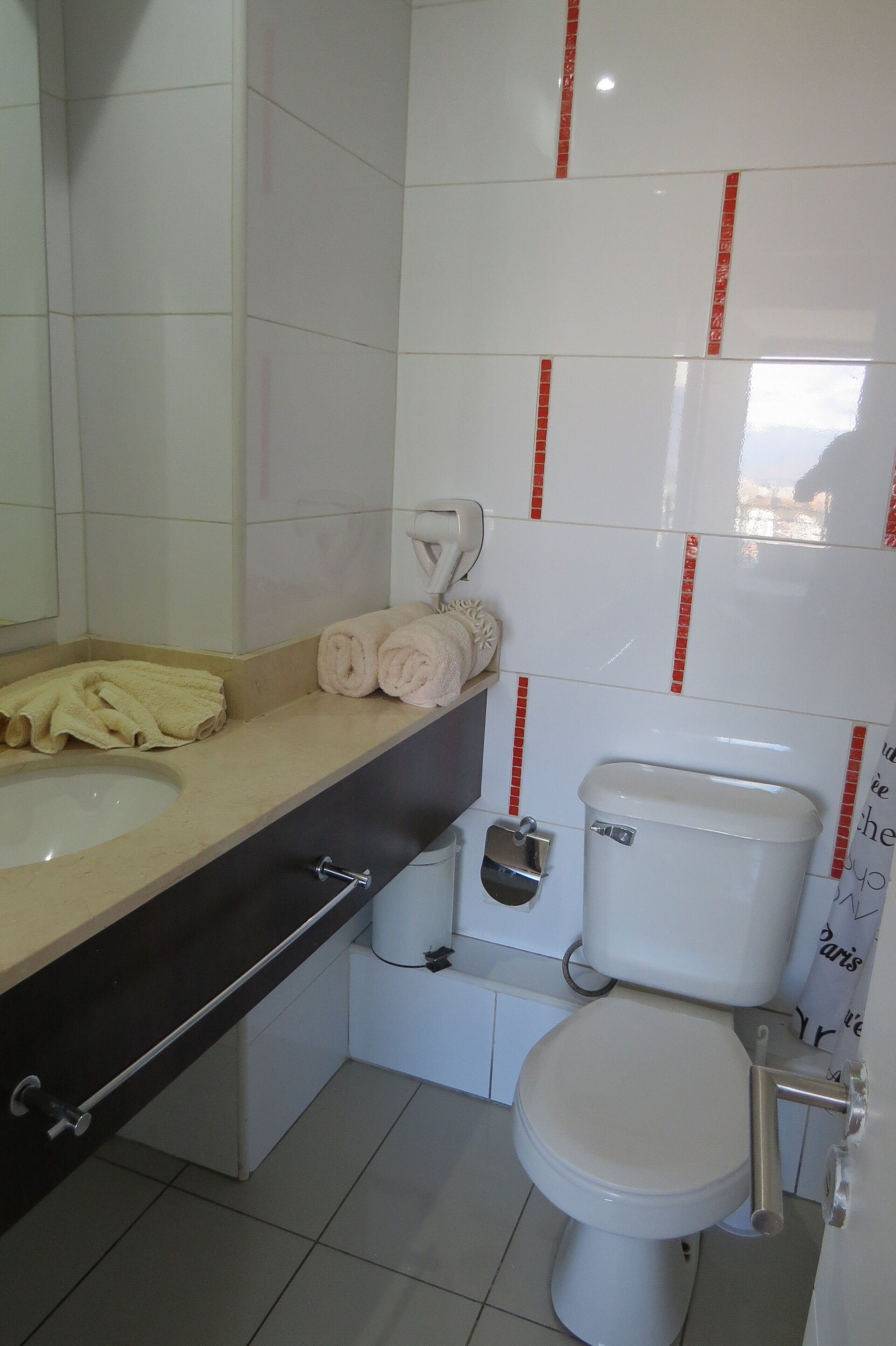 A bathroom with a sink, toilet, and towel rack.